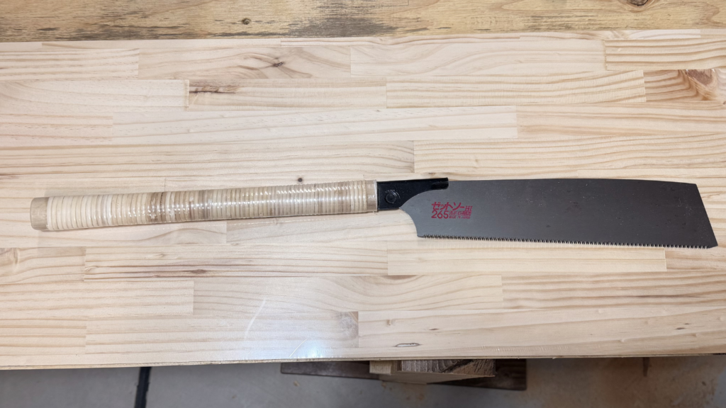 木材の作業台の上に置かれた、替刃式のこぎり「ゼットソー265」。