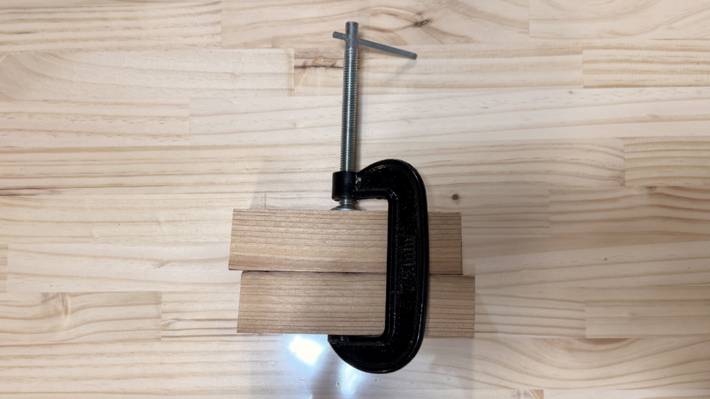 金属製Cクランプで木材を固定してる